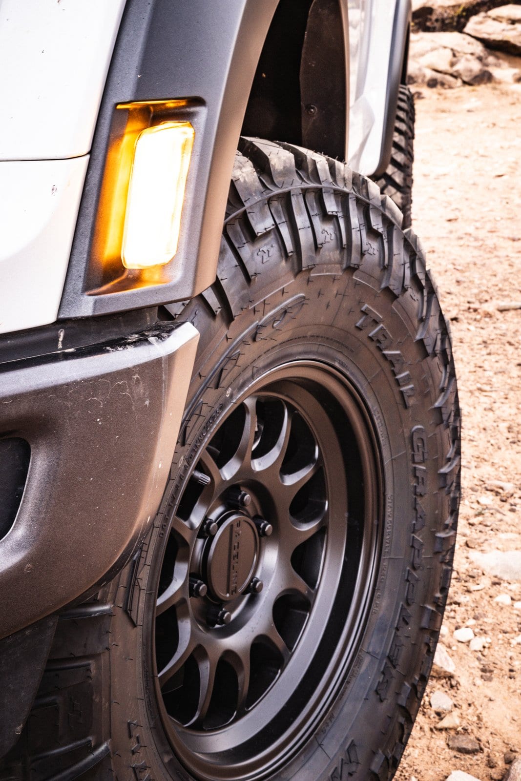 Close-up of an off-road tire and matte black wheel on a rugged truck
