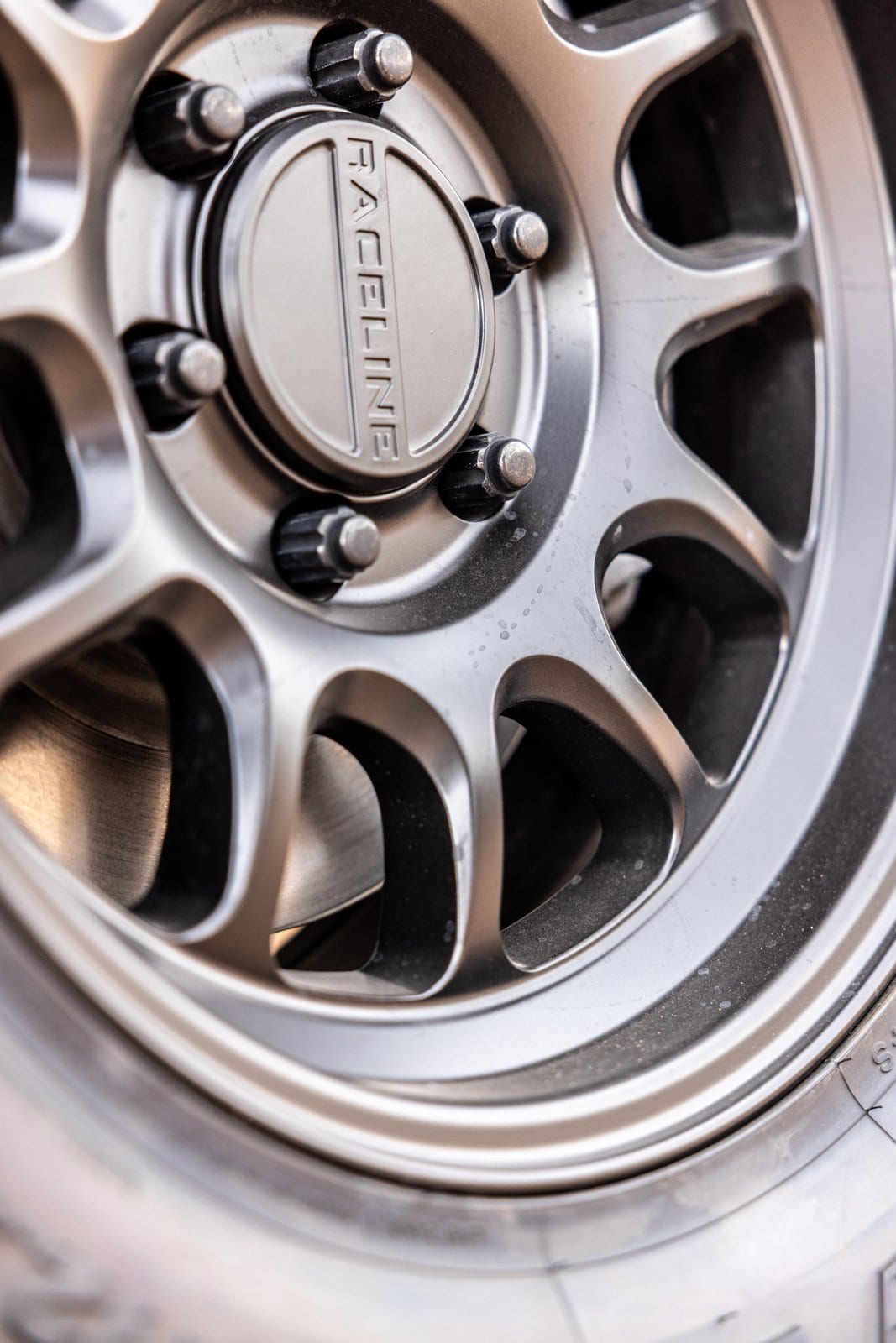 Close-up of a Raceline off-road wheel with metallic finish and visible lug nuts