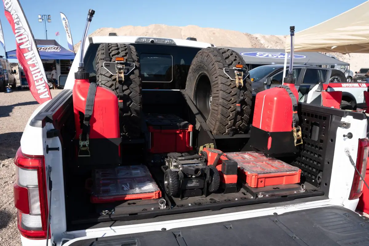 Rear view of an F-150 BASE bed layout with dual VSTMs, center tray, rear PACKOUT mounts and fuel jug holders