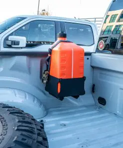 Wide view of the Ford BoxLink Fuel Jug Mount Kit installed beside the Ford pickup wheel well