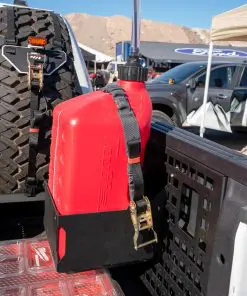 Ford BoxLink Fuel Jug Mount Kit installed at the bedside through the clearance hole in an AAL MOLLE panel