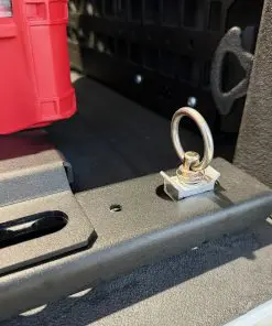 L-track ring connector seated in a dogbone cutout on the textured black F-150 BASE rail beside an M8 tapped hole.